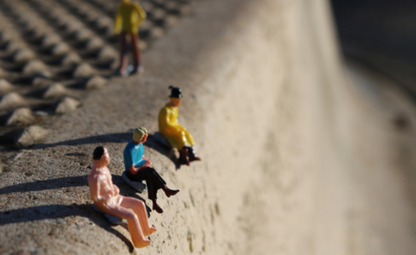Miniature figures sitting on a curb