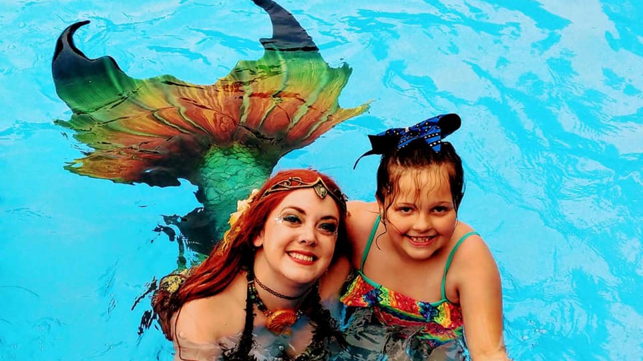A mermaid and a girl in a pool