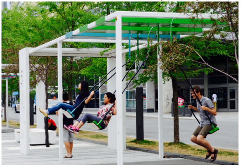 Adults playing on swings in an urban setting
